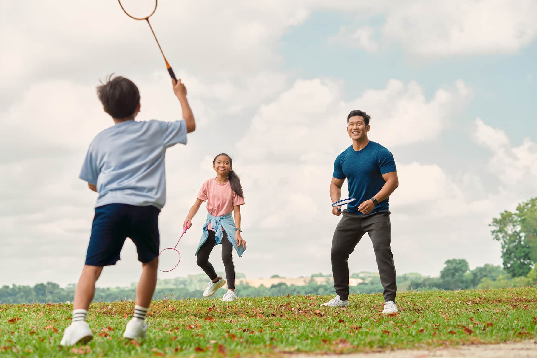 Family playing tennis outisde