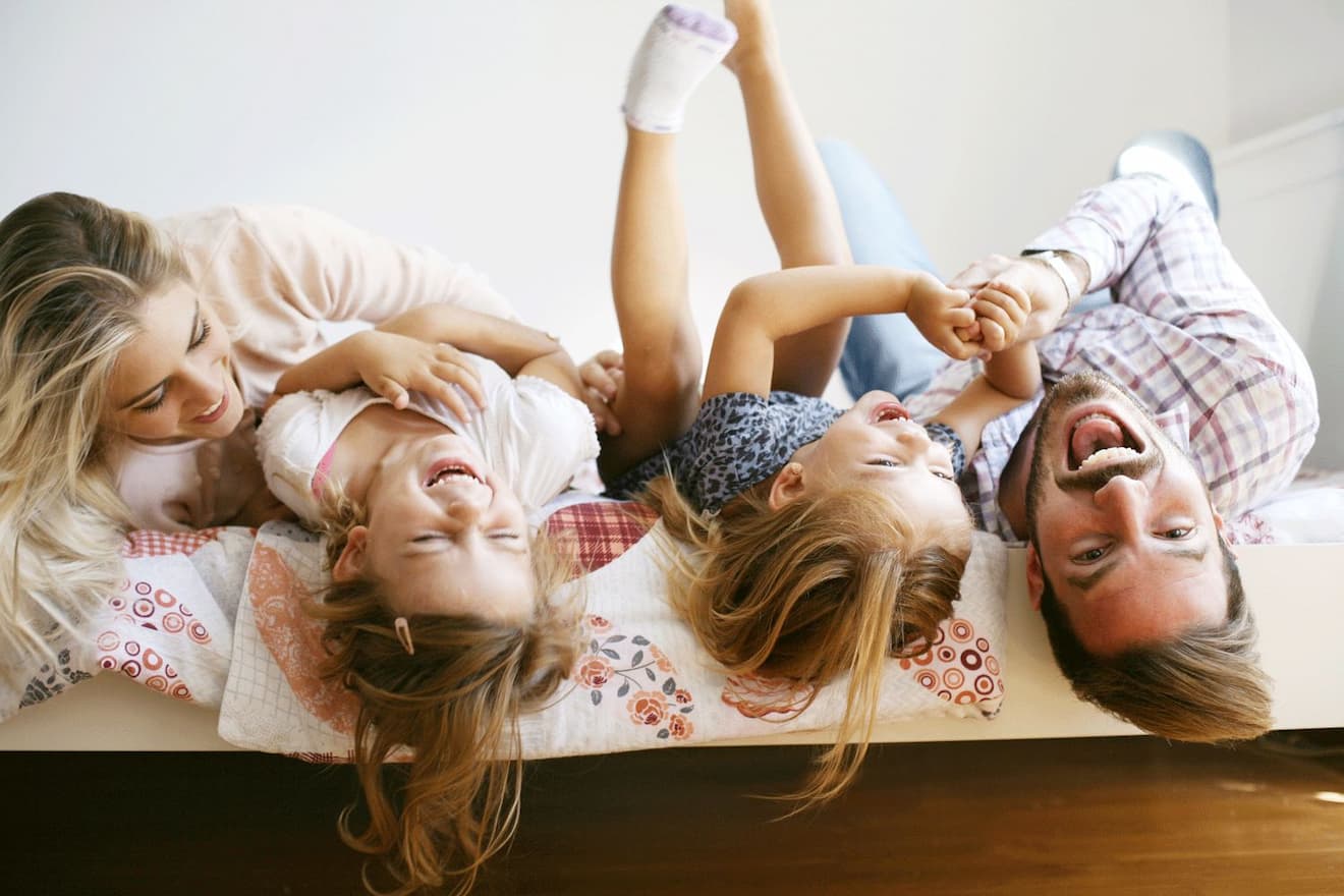 family laughing together on bed