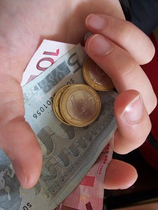 A €1 coin on a fiver and a €10 note