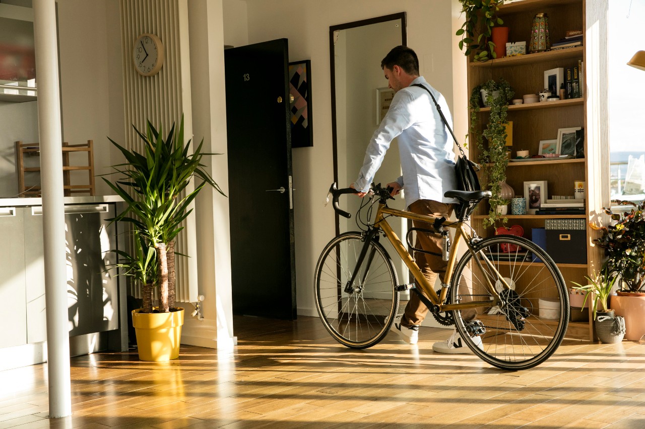 Man leaving apartment with bike