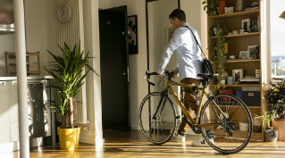 Man leaving his apartment with bike