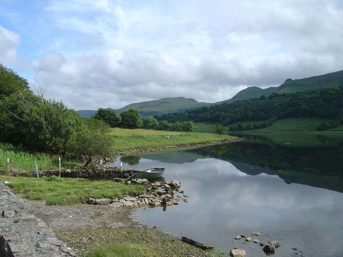 Green fields, a lake and mountains