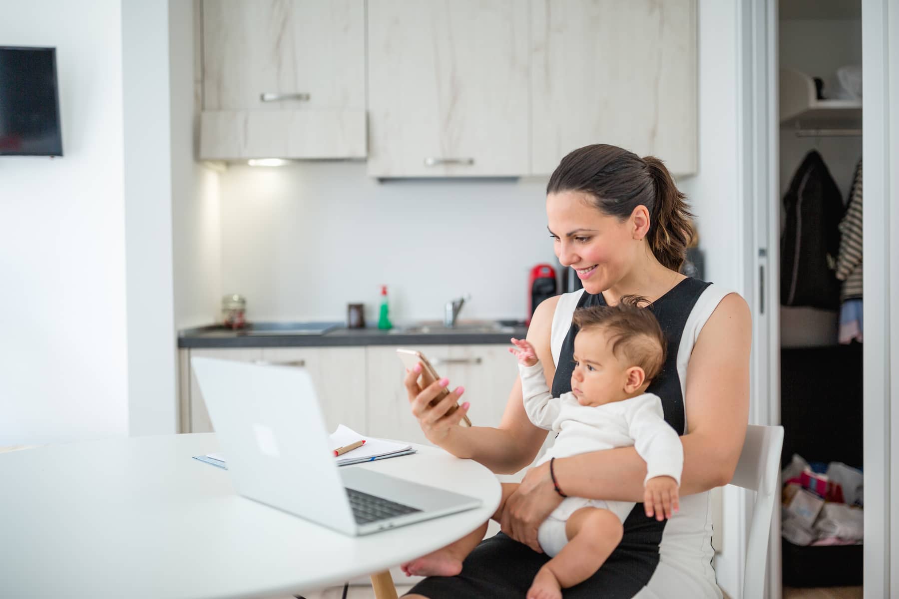 mother holding baby with laptop