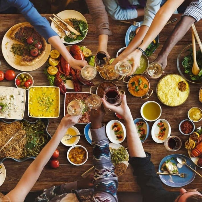 Toasting over a table with food